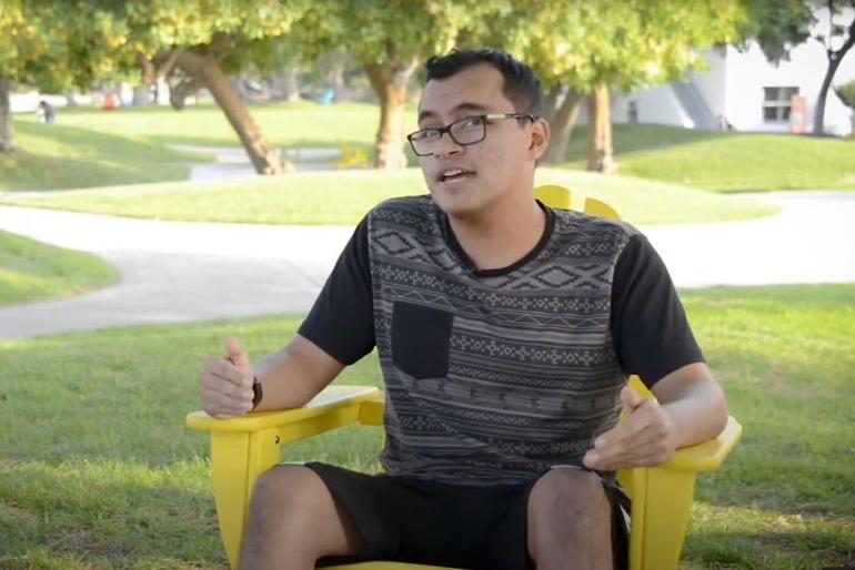 student sits on the mounds in a yellow chair